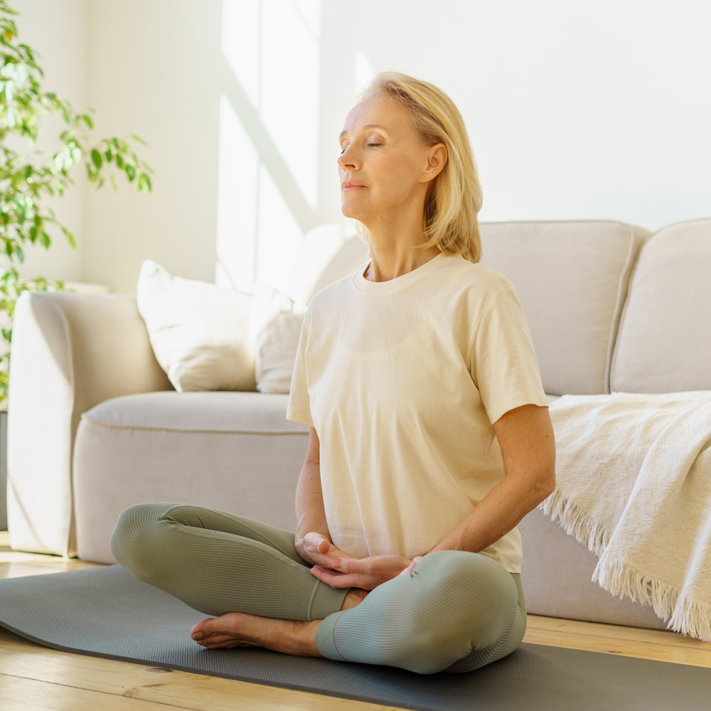 Frau sitzt auf dem Boden und macht eine Achtsamkeits-Übung