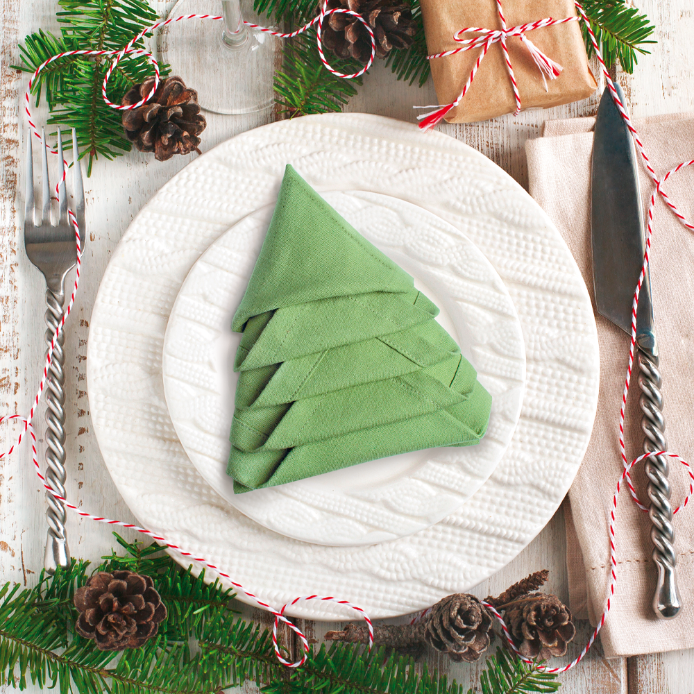 Serviette als Weihnachtsbaum auf einem festlich geschmückten Tisch